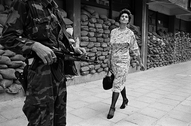 British photojournalist Tom Stoddart (1953-2021) photographed the strong "Woman of Bosnia" in 1995 with his Leica M6 (hiding in a shelter from the falling bombs when he saw this Bosnian woman walking tall and proud). 