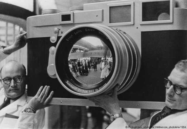 Photokina 1954 where two employees from Ernst Leitz Wetzlar (Leica Camera AG) carries a large Leica M3 camera model to the fair. © 1954 Photoglobus.