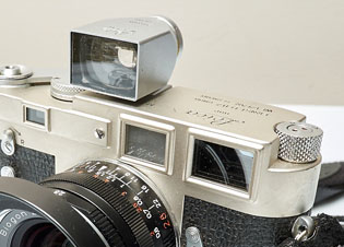 Leica M3 (1954) with a super-wide optical viewfinder on top of the camera so as to see what the frame will be. Built-in to the camera itself is the optical viewfinder (right) with a distance-finder image provided from the small eye to the left.