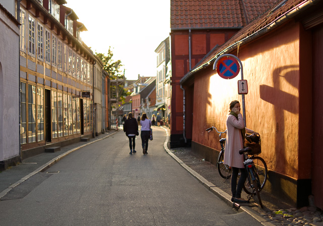 Perspective is relative position and distance. As here where the girl in front is more than two times taller than the people walking, and 8 times taller than the people in the far background. Also, the parts of the buildings closer to the viewer are 'taller' than the parts of the same building further away. Late afternoon sun in Denmark. Leica TL2 with Leica 35mm Summilux-TL ASPH f/1.4. © 2017 Thorsten Overgaard.