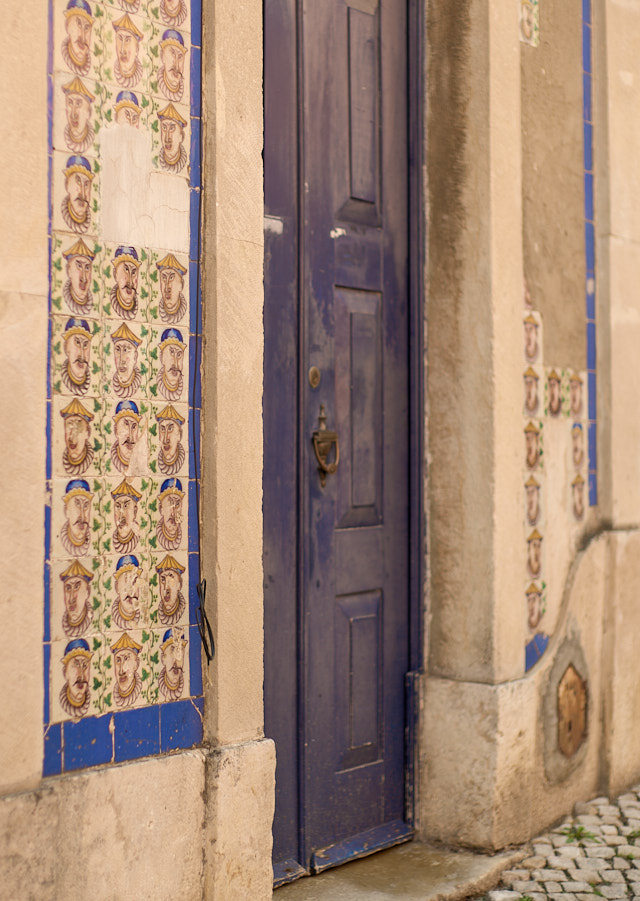 Many houses in Lisbon and Portugal have tiles as facade. This one has some outstanding asian faces that raise more questions than answers. But very unique. Leica M11 with Leica 50mm Noctilux f/0.95 FLE. © Thorsten Overgaard. 