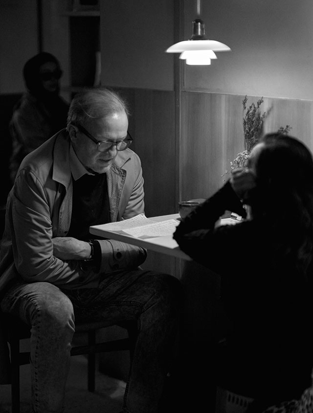 Inside the café La Cabra, a couple reading what appears to be letters from distant relatives. Notice the wood panels, the Danish Louis Poulsen lamp, and the clay coffee mugs—all are part of making life in cold and dark countries a cozy and stylish affair. 1600 ISO. Leica 50mm Noctilux-M ASPH f/0.95. © Thorsten Overgaard.