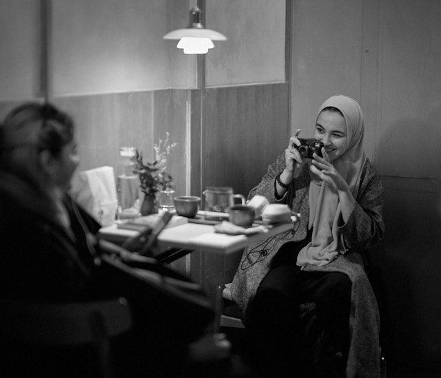 While, at the next table, a girl is taking a 35mm film photo of a firned. Leica M10-R with Leica 50mm Noctilux-M ASPH f/0.95. © Thorsten Overgaard. 