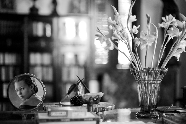 Depth of Field as seen by the extreme f/0.95 50mm Leica Noctilux lens: Focus is on the flowers and the photograph on the desk, and the foreground and background are blurred as the depth of focus is narrow. You can produce something similar with a 28mm f/1.7 if you go closer, because the closer you focus, the narrower the depth of focus will be. Similarly, the further away the background, the less in focus it will be (long backgrounds or 'long shot').