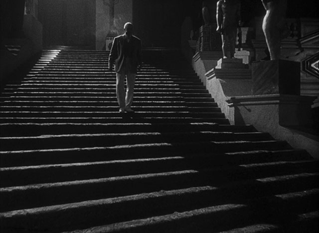A strong light source from behind (top left outside the frame) adds long shadows and edge light that defines the person, the stairs and the statues. Citizen Kane (1941, cinematography by Gregg Toland, directed by Orson Welles).