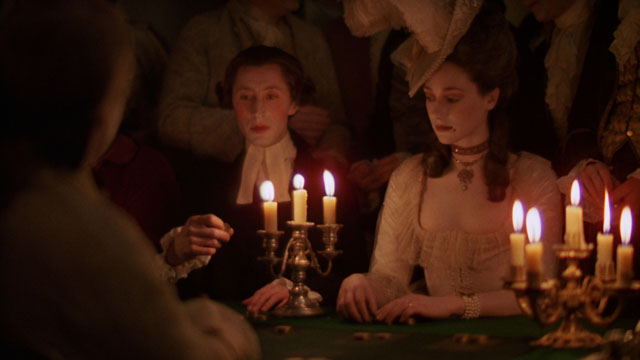 Stanley Kubrick's candlelight lit scene in Barry Lyndon is famous for being shot using only candlelights and special-made Zeiss 50mm f/0.7 lenses. He might have adjusted the color slightly with filters, but else it is close to the actual look which is not because it is low light, but because the light from candles is warm light.  